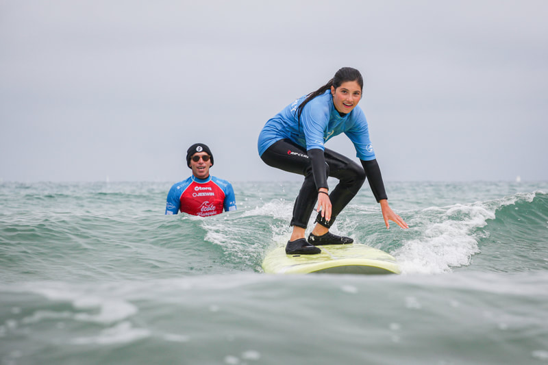 Apprendre les bases du surf et se lever sur sa planche de surf.