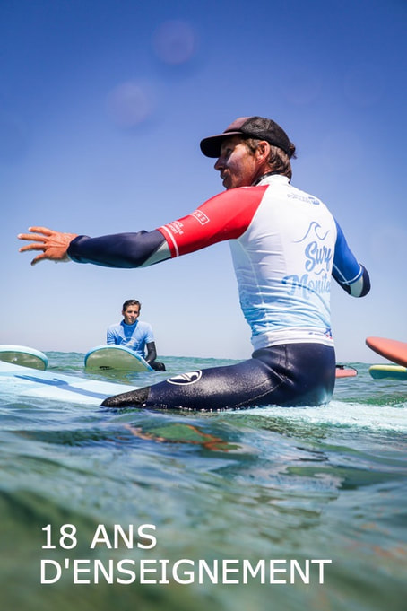 Le moniteur de l'école Surf Harmony apprend à ses élèves comment prendre les vagues.